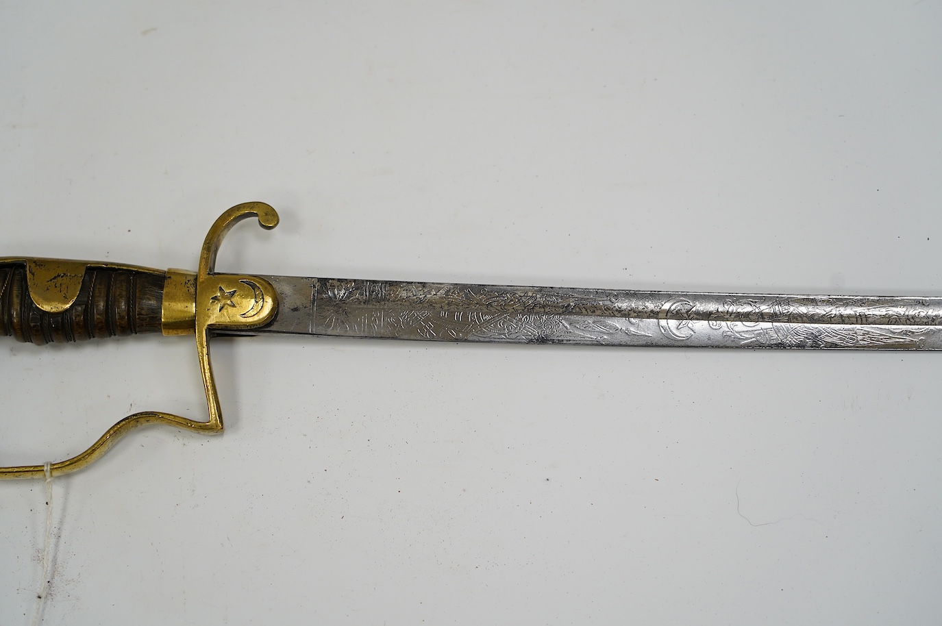 A Turkish WWI artillery sword, etched blade, Vanran Tagirian, Constantinople, brass stirrup hilt and horn grip, blade 70.5cm. Condition - fair, well worn